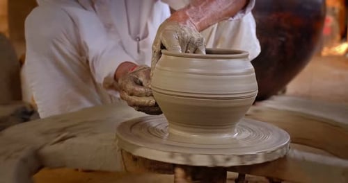 Des mains habiles de potier façonnent l'argile sur Potter Wheel et sculptent un pot en argile. Shipagramme