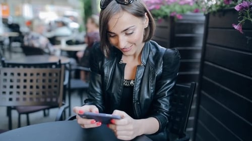 Woman Using Mobile Phone at Urban Cafe