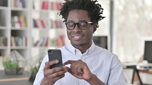 Young Man Using Smartphone Indoors
