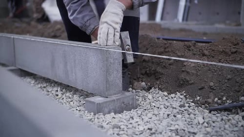 footage of builder installs curb