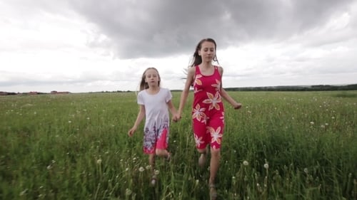 Young Girl Running In a Field Holding Hands