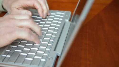 Hands Typing on a Silver Laptop Computer
