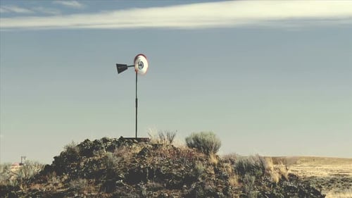 Decorative Windmill Standing on Hill in Rural Desert