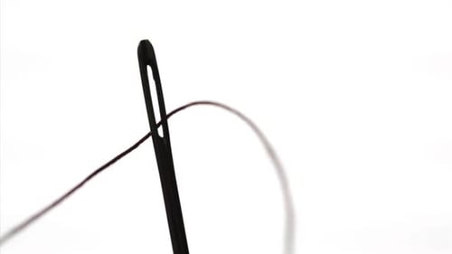 Thread Being Inserted into Sewing Needle Eye