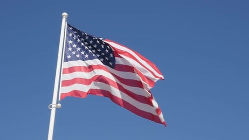 American Flag Waving Against Clear Blue Sky