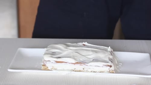 Woman Frosting a Layer Cake with Icing