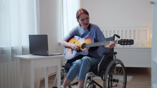 Woman in Wheelchair Plays Guitar at Home
