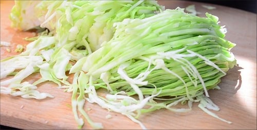 Fresh Green Cabbage Being Chopped on Board