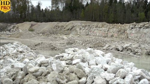 Open Stone Quarry with Rock Piles and Murky Water