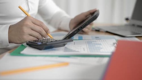 Accountant Using Calculator to Review Financial Data