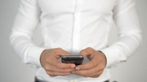 Man's Hands Typing on Mobile Device