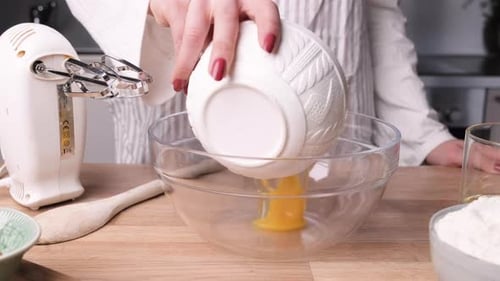 Woman Pouring Eggs and Sugar into Glass Bowl. - Slider Right