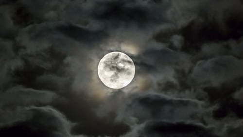 Heller Mond zwischen sich bewegenden Wolken
