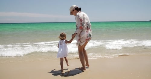 Mother And Daughter Enjoying The Beach On Summer