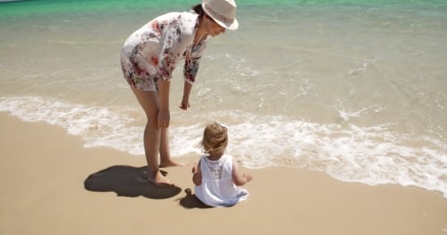 Mom Watching Over Her Girl Enjoying At The Beach