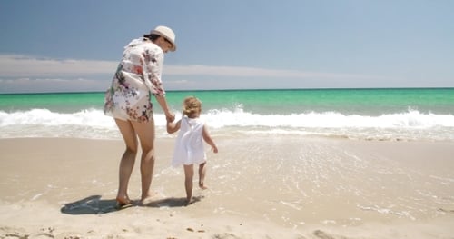 Cute Girl With Mummy On The Beach