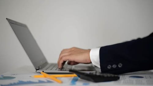 Man's Hands Typing on Laptop Keyboard in Office