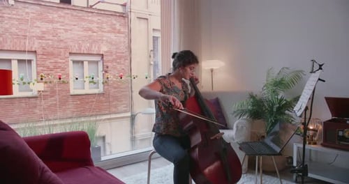 Woman Plays Cello in Apartment During Daytime