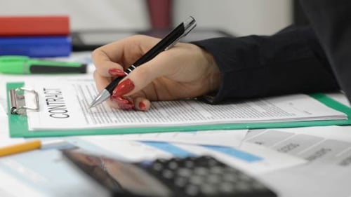 Woman Signing Business Contract in Office Setting