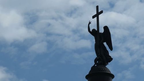Silhouetted Angel Monument Under Cloudy Skies