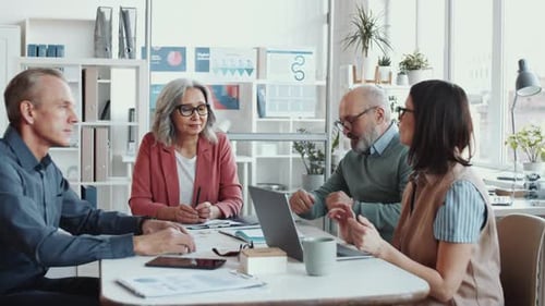 Mixed-Aged Business Team Having Discussion at Office Meeting
