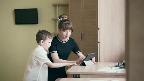 Woman and Child Interact With Tablet Indoors