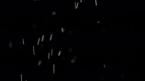 Las manchas blancas flotantes de polvo brillan sobre fondo negro