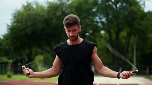 Cropped Shot of Muscular Man Standing on Running Track Outdoors on Modern Stadium Doing Exercise