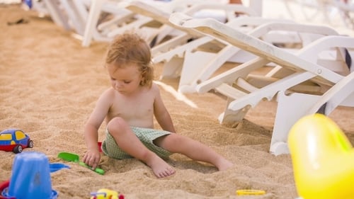 Child Playing with Toys on Sandy Beach