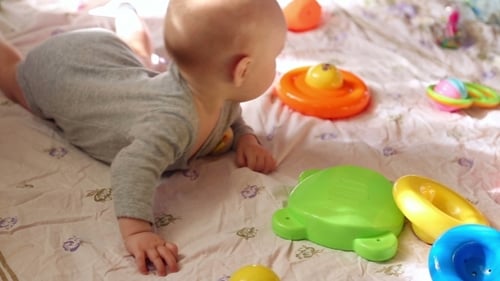 Adorable Infant Lying with Toys on Play Mat