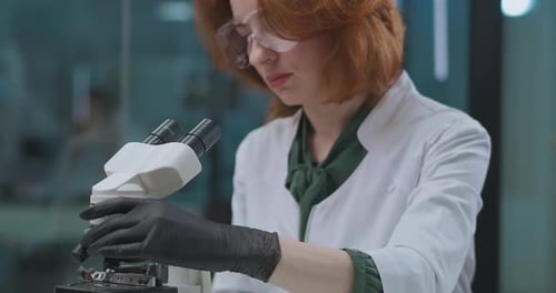 Woman Scientist Using Microscope in Modern Laboratory