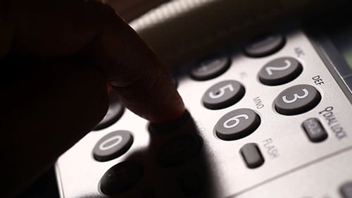 Finger Dialing Numbers on Telephone Keypad Close Up