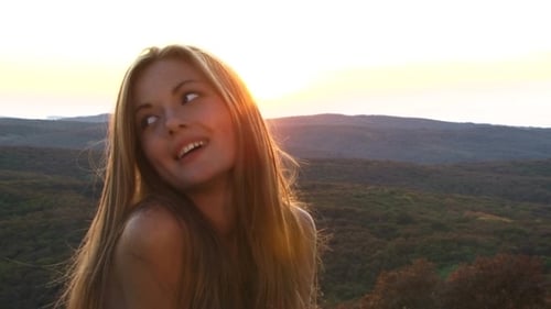 Woman Smiles Near Scenic Landscape During Golden Hour