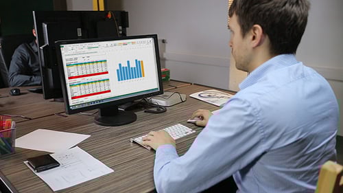 Man Working with Data at Computer in Office