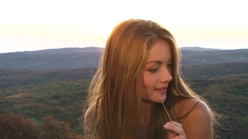 Young Woman Smiling With Grass at Sunset