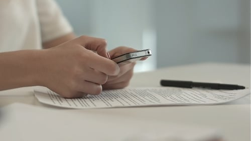 Woman Using Smartphone at Office Desk