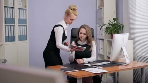 Businesswomen Working Together on Tablet in Office