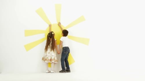 Boy and Girl Holding Hands Near Yellow Sun