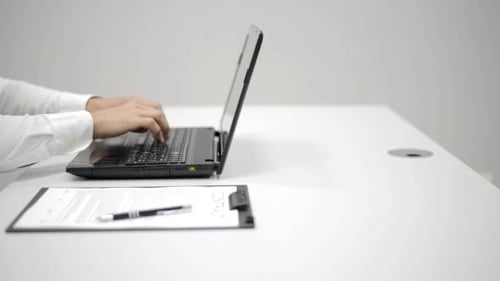 Man Typing on Laptop