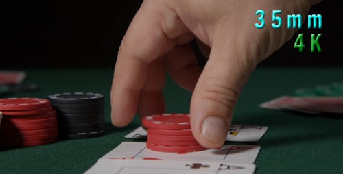 Hand Places Chips on Poker Cards to Bet
