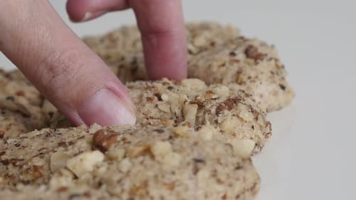 Finger Taking Portion of a Nutty Cookie