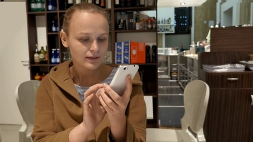 Young Adult Using Smartphone Inside Cafe