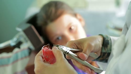 Dentist Adjusts Dental Retainer for Child Patient