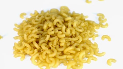 Dry Elbow Macaroni Pasta on a White Surface