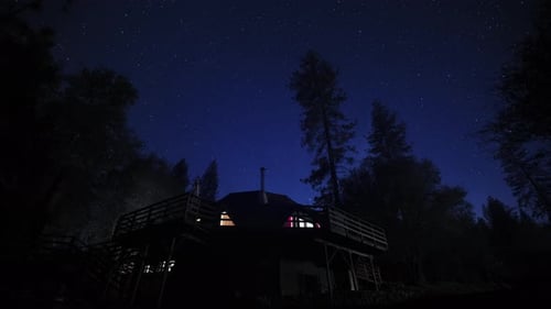 Scenic Timelapse of Bright Stars in Night Sky Over Cozy Dome Cottage in Forest