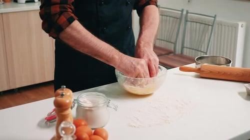 Man mixing ingredients in glass bowl in kitchen