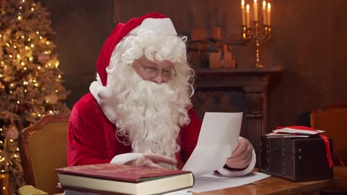 Santa Claus Reading Christmas Letter Indoors at Night