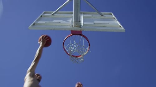 Young Adult Sinking a Basketball Dunk Outdoors
