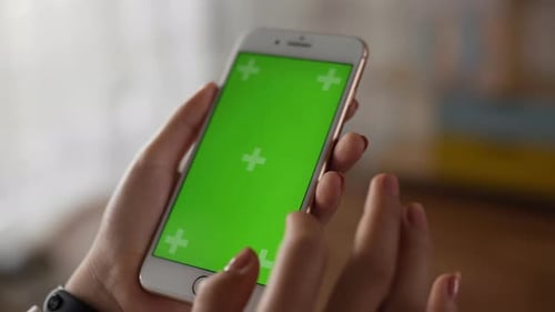 Closeup of hand woman using smartphone with green screen