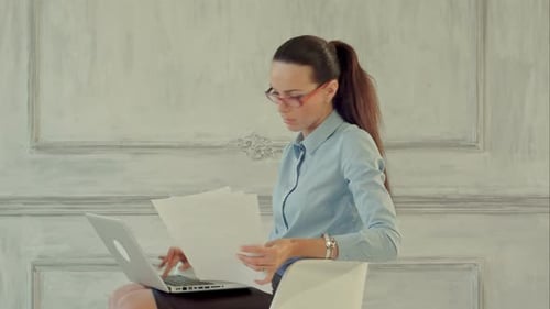 Professional Woman Works with Laptop and Documents
